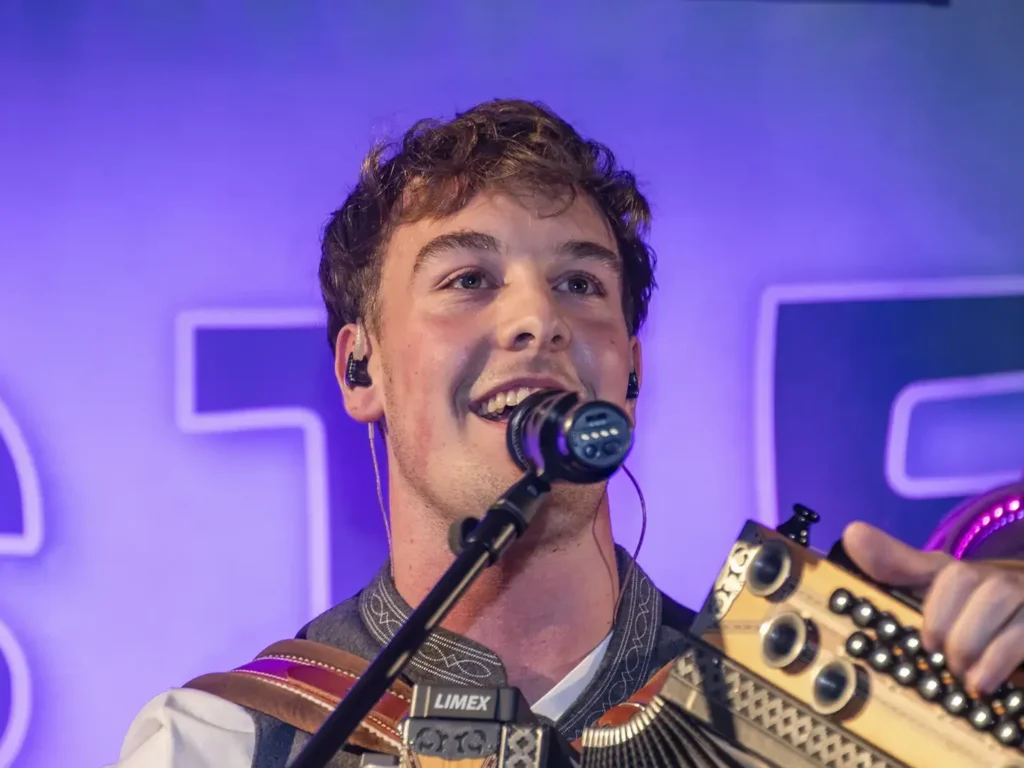 Lukas Strasser mit Harmonika und Mikrofon auf der Bühne