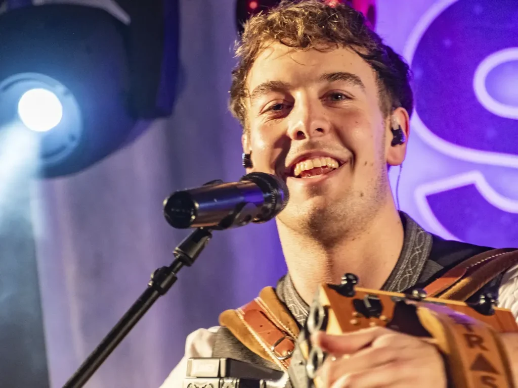 Lukas Strasser lächelt mit Harmonika in die Kamera